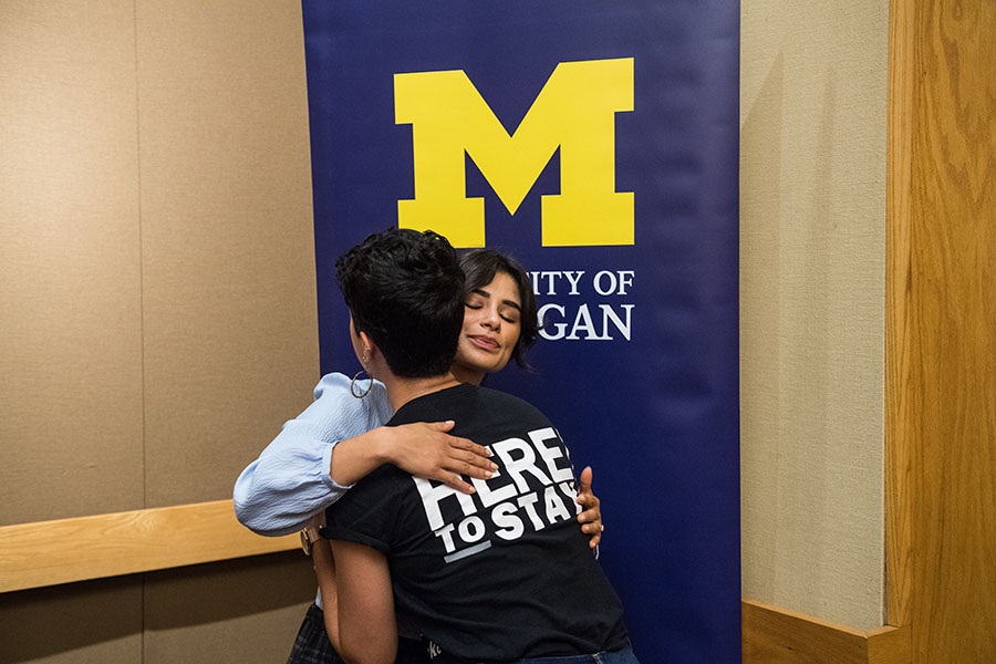 Actress and activist Diane Guerrero hugs a student backstage.