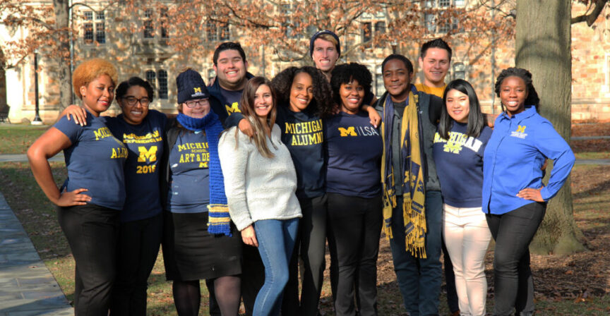 group of MCAC advisers wearing Michigan gear outside in the fall.